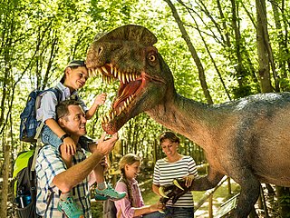 Das Bild zeigt eine Familie im Dinopark Teufelsschlucht.