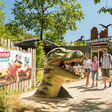 Das Bild zeigt eine Familie im Dinopark Teufelsschlucht.